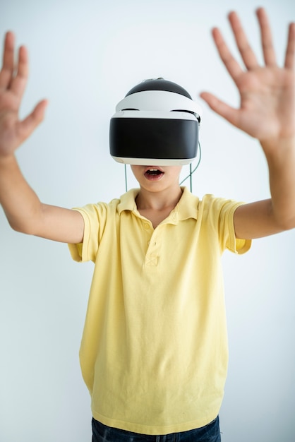 Vista frontale bambino che gioca con gli occhiali vr