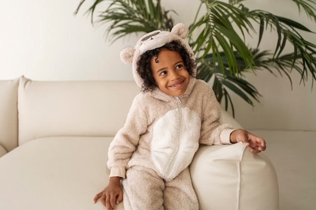 Free photo front view kid sitting on couch