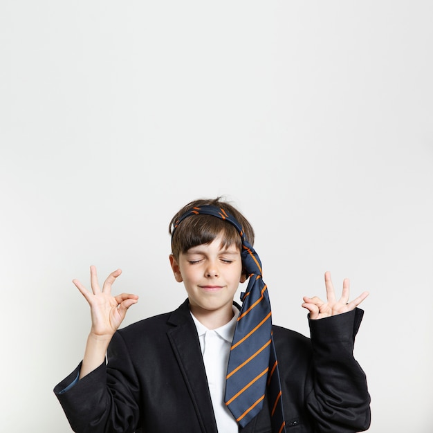 Free photo front view kid in a suit meditating