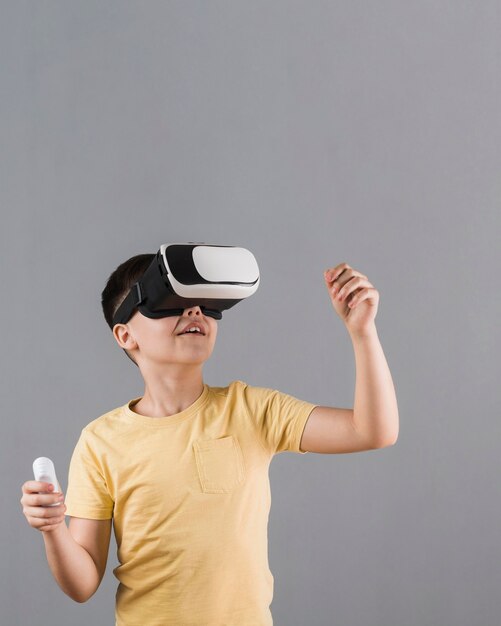 Front view of kid using virtual reality headset with copy space