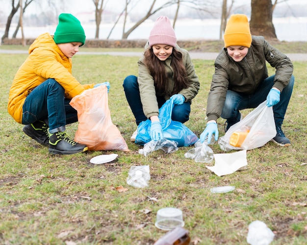 Vista frontale di bambini che puliscono il terreno