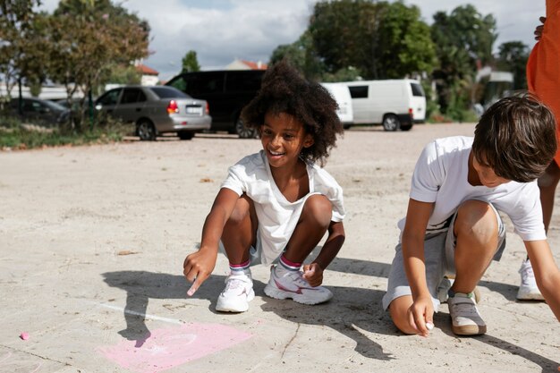 Вид спереди дети рисуют на тротуаре
