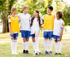 Foto gratuita ragazzi di vista frontale in abbigliamento sportivo da calcio che si guardano l'un l'altro