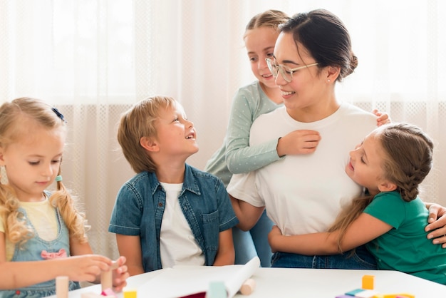 正面を向いた子供たちが先生を抱いて