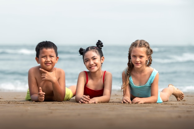 Bambini di vista frontale sdraiati sulla spiaggia