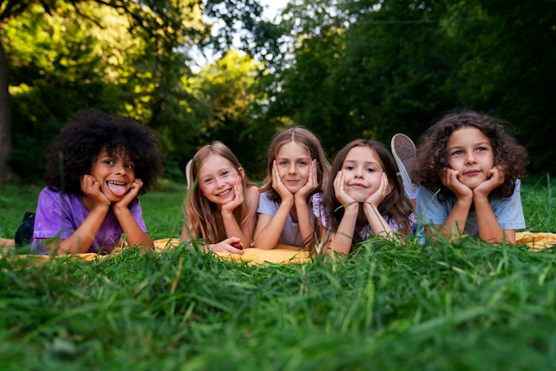 Free photo front view kids laying together outdoors