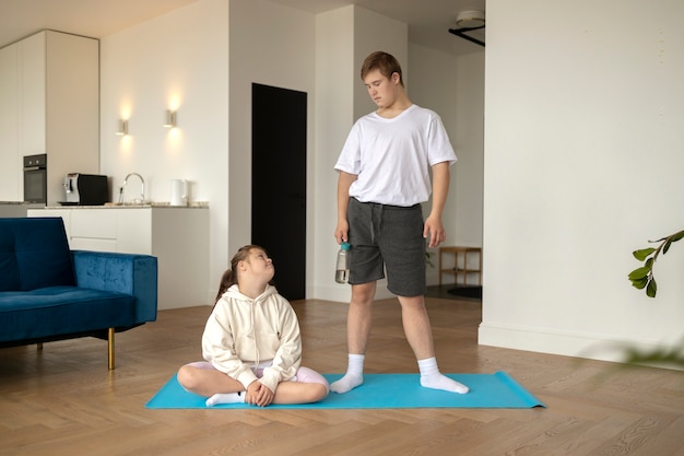 Free photo front view kids meditating on mat