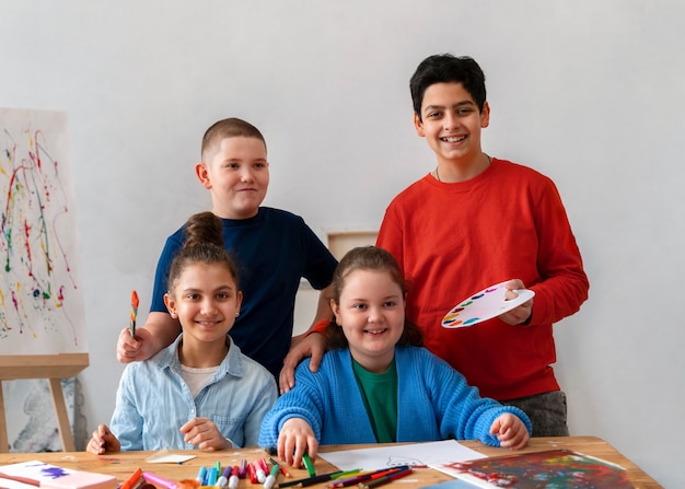 Foto gratuita bambini di vista frontale che posano alla scuola