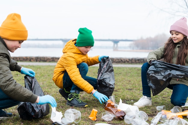 Free photo front view of kids recycling on ground