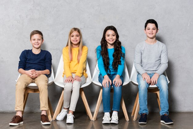 Front view kids sitting on chairs