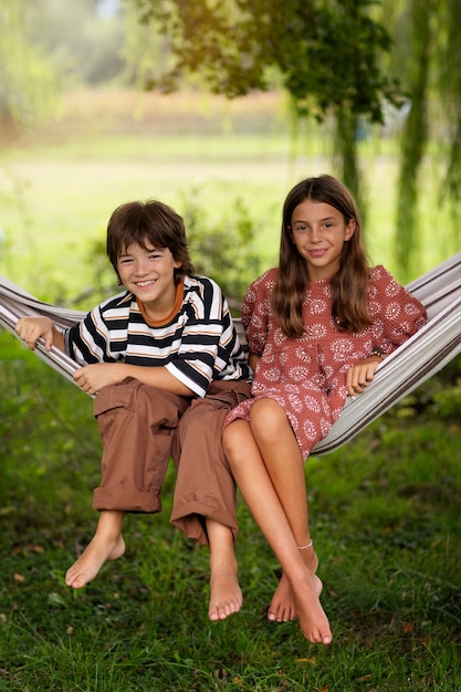 Front view kids sitting in hammock