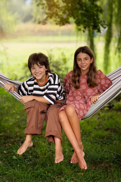 Front view kids sitting in hammock