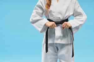 Free photo front view of kimono on little fighter keeping black belt