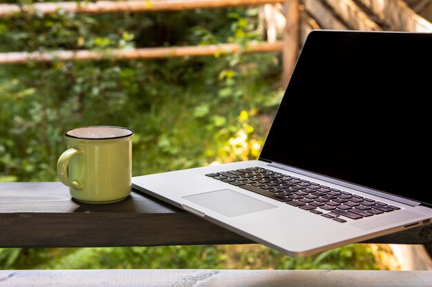 Front view laptop and cup of coffee