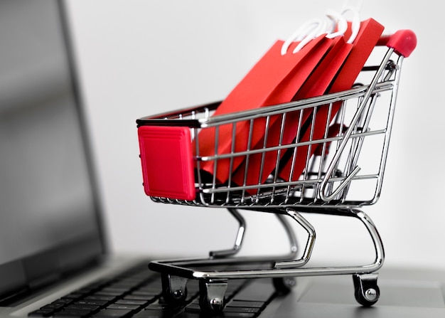 Front view of laptop with shopping cart and bags for cyber monday