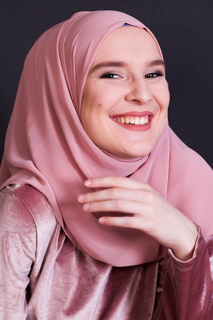 Front view of laughing woman on black backdrop