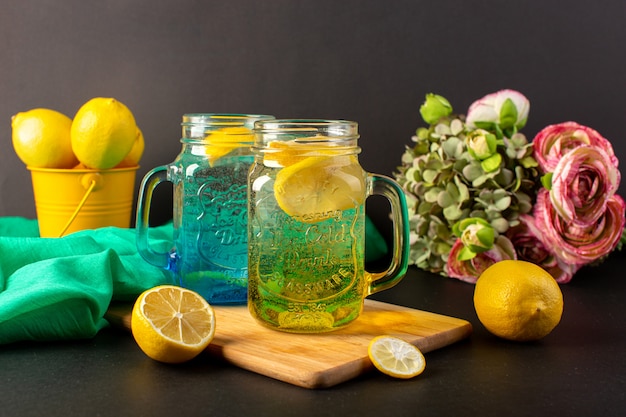 유리 컵 안에 레몬 칵테일 신선한 시원한 음료 어두운 배경 칵테일 음료 과일에 꽃과 함께 슬라이스 및 전체 레몬