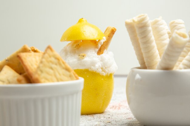 Front view lemon cocktail with ice and crackers on white table citrus cocktail juice