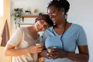 Free photo front view lesbian couple with coffee cups