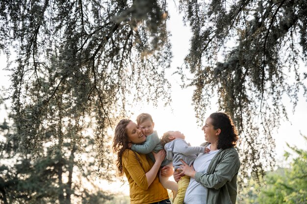 Front view of lgbt mothers outside in the park with their children