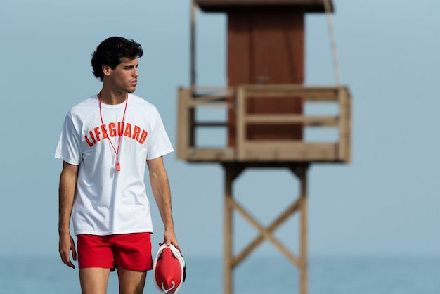 Free photo front view lifeguard holding lifesaving buoy