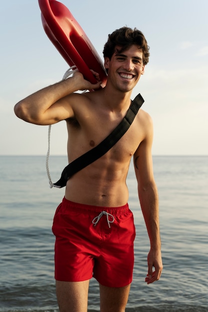 Front view lifeguard holding lifesaving buoy