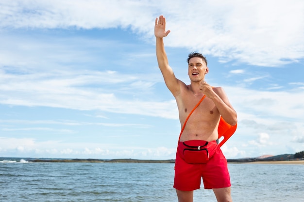 Front view lifeguard waving at someone