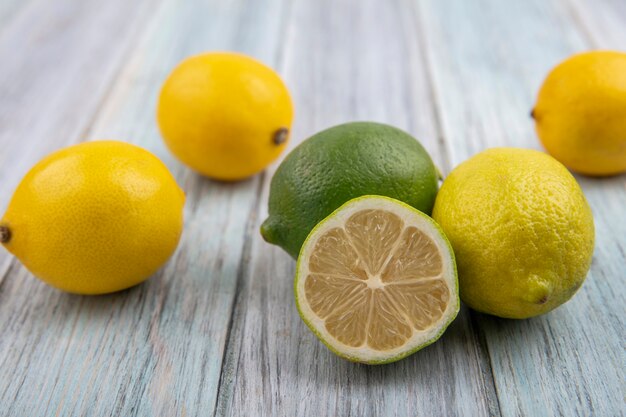 Лаймы с лимонами на сером фоне вид спереди