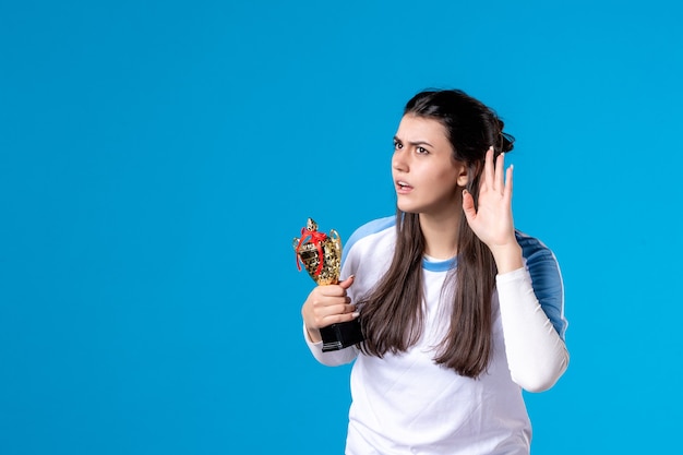 Front view listening female player with cup on blue 