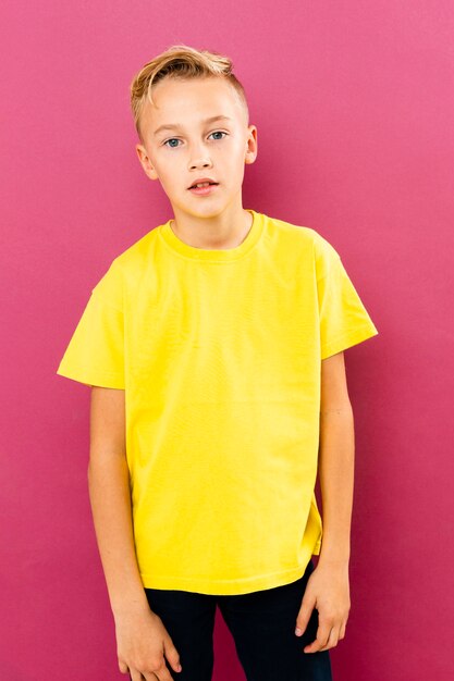 Front view little boy posing on pink background