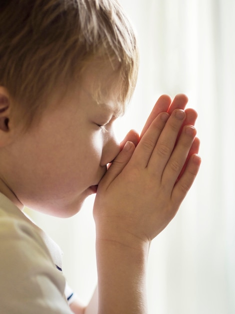 Front view of little boy praying