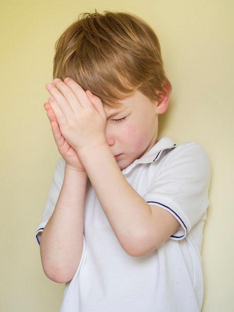 Free photo front view of little boy praying