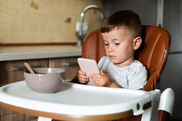 電話を使用して正面の小さな男の子