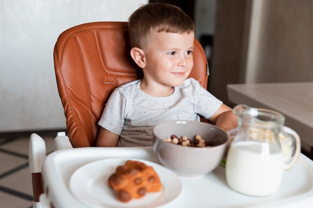 Front view little boy with assortment of snacks