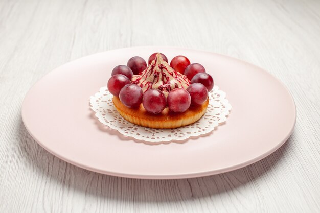 Front view little cake with grapes inside plate on white background