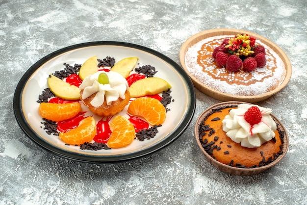 Бесплатное фото Вид спереди маленький торт с нарезанными фруктами и пирогом на белом фоне, сладкий фруктовый торт, печенье, сахарное печенье