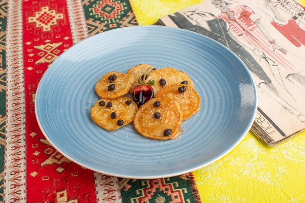 Front view little cookie pastries inside blue plate on the yellow table, bake sweet tea pastry