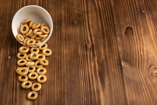 Foto gratuita vista frontale piccoli cracker all'interno del piatto su una superficie di legno