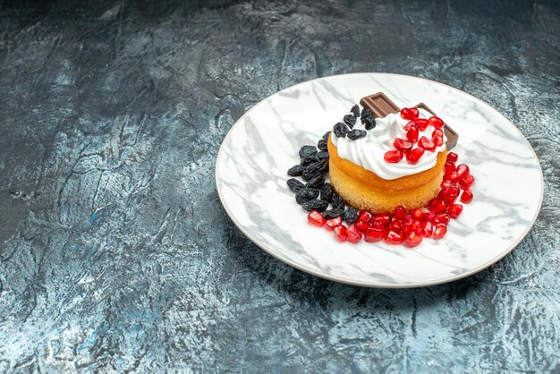 Front view little delicious cake with chocolate and raisins on light-dark background