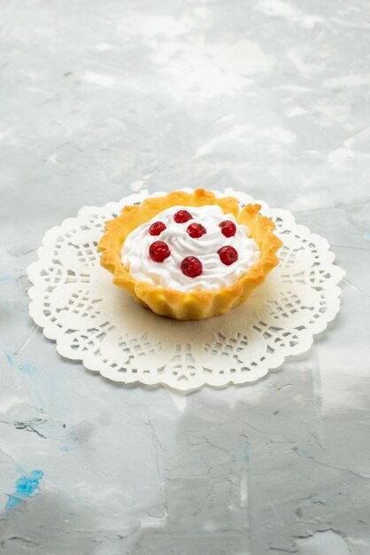 Free photo front view little delicious cake with cream and red cranberries isolated on the light surface