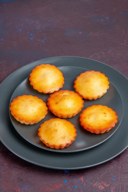 Front view little delicious cakes inside plate on a dark background pie biscuit cake sweet tea cookie sugar