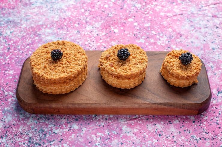 Free Photo front view of little delicious cakes round formed on pink surface