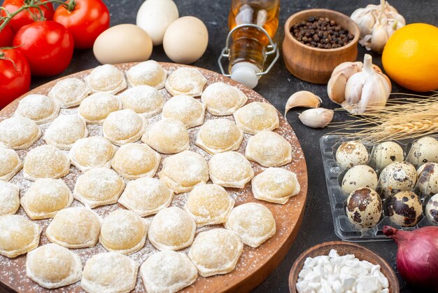 Front view little dough with flour and eggs on dark background pie dumpling dough bun color cake meat hotcake