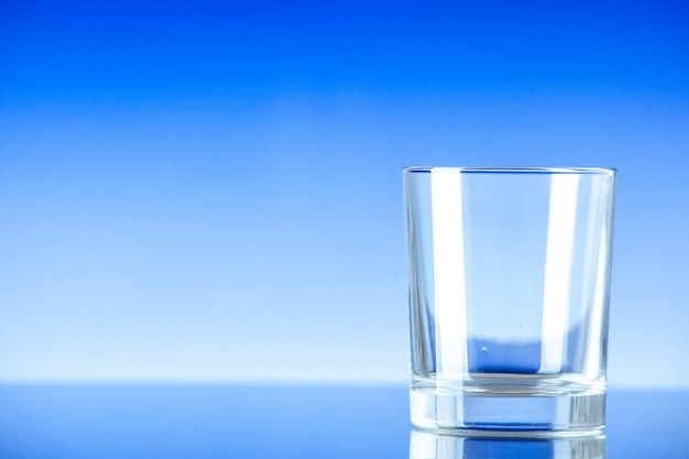 Вид спереди маленький пустой стакан на синей поверхности