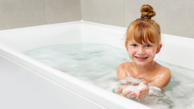 Free photo front view little girl in the bathtub