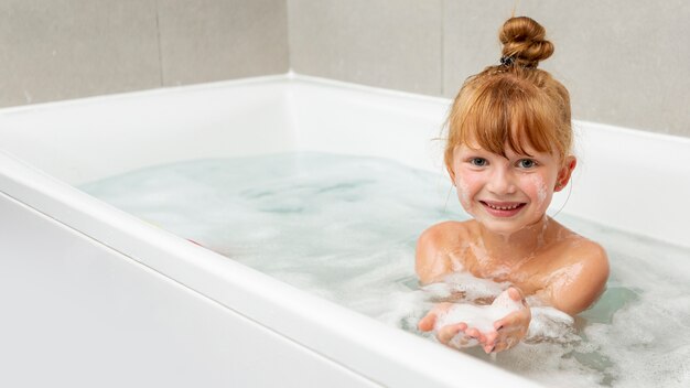 Front view little girl in the bathtub