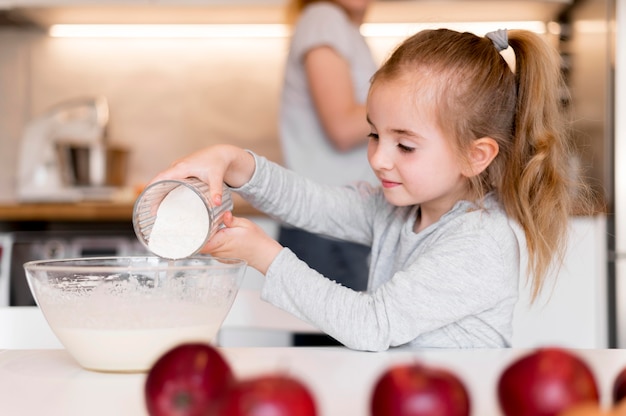 Free photo front view of little girl cooking at home