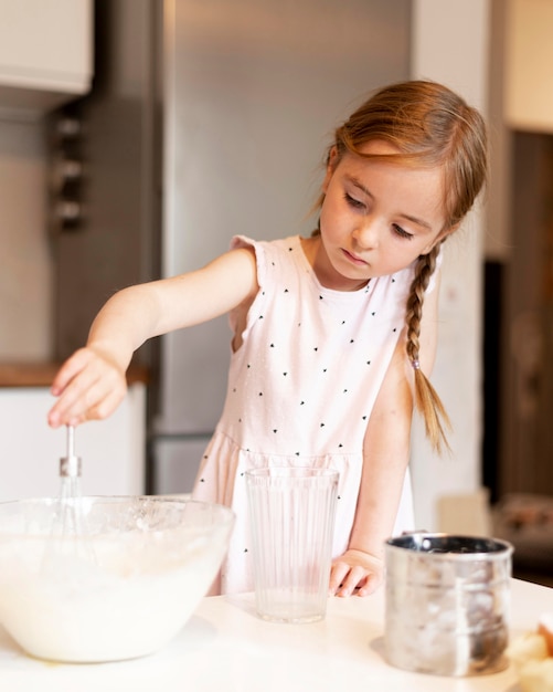 Вид спереди маленькой девочки, приготовление пищи дома