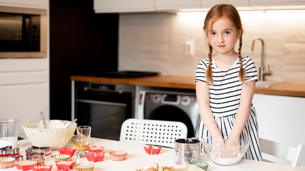 Front view of little girl cooking at home