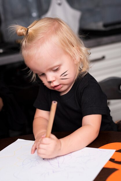 Front view of little girl drawing in the kitchen